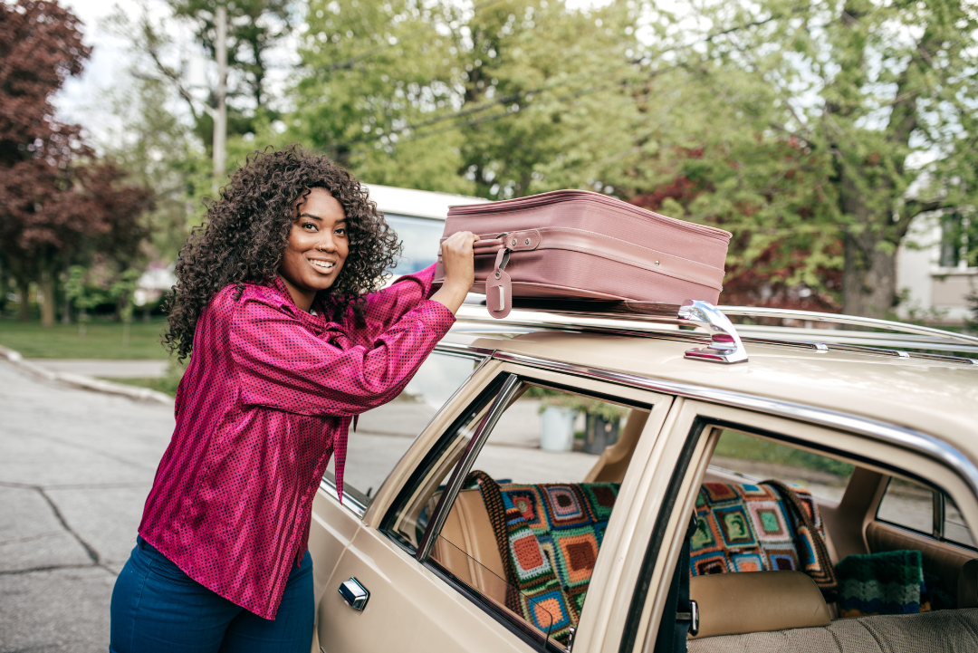 Woman loading car with luggage.